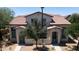 Charming home featuring a tile roof, desert landscaping, and a welcoming entrance with dual doorways and shade trees at 14870 W Encanto Blvd # 1038, Goodyear, AZ 85395