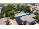 Aerial view showcases the community pool with ample seating, a nearby building, and mature landscaping at 14870 W Encanto Blvd # 1038, Goodyear, AZ 85395
