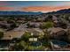 Stunning aerial view of a luxury home with a private pool, lush landscaping, and mountain views at sunset at 15411 S 13Th Ave, Phoenix, AZ 85045