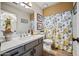 Bathroom with a gray vanity, marble countertop, decorative shower curtain, and wood-look flooring at 15411 S 13Th Ave, Phoenix, AZ 85045