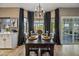 Elegant dining room with a large table, seating for eight, stylish curtains, and hardwood floors at 15411 S 13Th Ave, Phoenix, AZ 85045