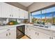 Bright kitchen featuring white cabinets, stainless steel appliances, and a garden view at 15411 S 13Th Ave, Phoenix, AZ 85045