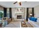 Cozy living room featuring a stone fireplace, plush seating, and large windows for natural light at 15411 S 13Th Ave, Phoenix, AZ 85045