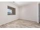 A bedroom featuring wood-look tile flooring and a window bringing in natural light at 17308 W Royal Palm Rd, Waddell, AZ 85355