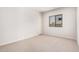 Bedroom with neutral carpet, a window, and a door leading to the hallway at 17308 W Royal Palm Rd, Waddell, AZ 85355
