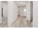 Bright hallway with wood-look tile flooring, leading to the front door and other rooms in the house at 17308 W Royal Palm Rd, Waddell, AZ 85355
