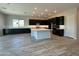 Spacious kitchen boasts a large center island, black cabinets, and stainless appliances at 17308 W Royal Palm Rd, Waddell, AZ 85355
