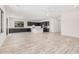 Bright, open-concept kitchen and living area with dark cabinetry, light countertops, and wood-look tile flooring at 17308 W Royal Palm Rd, Waddell, AZ 85355