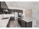 A modern kitchen features dark cabinets, stainless steel appliances, and an oversized island with a stainless apron sink at 17308 W Royal Palm Rd, Waddell, AZ 85355