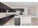 Modern kitchen with dark cabinets, stainless steel appliances, and a large island at 17308 W Royal Palm Rd, Waddell, AZ 85355
