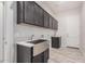 A stylish laundry room with a stainless steel sink, shaker cabinets, and a convenient utility sink at 17308 W Royal Palm Rd, Waddell, AZ 85355