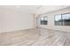 Bright and airy living room featuring wood-look tile flooring, large windows, and recessed lighting at 17308 W Royal Palm Rd, Waddell, AZ 85355