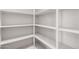 Walk-in pantry with rows of white shelves for maximum storage in this home at 17308 W Royal Palm Rd, Waddell, AZ 85355