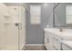 Bathroom featuring walk-in shower with glass door and vanity with white cabinets and stainless steel hardware at 19751 W Adams St, Buckeye, AZ 85326