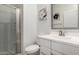 Bathroom featuring a walk-in shower with glass door, white vanity and soft natural lighting at 19751 W Adams St, Buckeye, AZ 85326