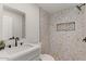 Chic bathroom boasts stone tile, modern vanity, black fixtures, and recessed shower niche at 2036 W Windrose Dr, Phoenix, AZ 85029