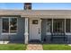 Close up of home's facade showcasing front door, bench, gravel yard and manicured strip of grass at 2036 W Windrose Dr, Phoenix, AZ 85029
