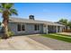 View of home's exterior, showcasing gravel landscaping, driveway and small grass yard leading to entrance at 2036 W Windrose Dr, Phoenix, AZ 85029