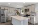 Updated kitchen showcases stainless steel appliances, white cabinets, quartz countertop, and kitchen island at 2036 W Windrose Dr, Phoenix, AZ 85029