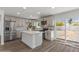 Bright kitchen features stainless steel appliances, an island, white cabinets and sliding glass doors to the exterior at 2036 W Windrose Dr, Phoenix, AZ 85029