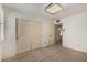 A carpeted bedroom with a double door closet, light fixture and a view to the next room at 2050 W Nido Ave, Mesa, AZ 85202
