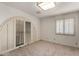 A simple bedroom features neutral carpet and an arched window with shutters for natural light at 2050 W Nido Ave, Mesa, AZ 85202