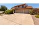Exterior of the house featuring a tile roof, spacious driveway, and manicured bushes at 2050 W Nido Ave, Mesa, AZ 85202