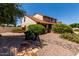 Charming two-story home with tile roof complemented by a stone walkway and mature landscaping at 2050 W Nido Ave, Mesa, AZ 85202