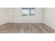 Bright bedroom features wood-look floors, a window, and a door at 2117 W 2Nd St, Mesa, AZ 85201