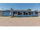 Back exterior view of single story home with laundry area, gravel yard, and greenery at 2117 W 2Nd St, Mesa, AZ 85201