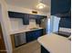Well-lit kitchen with white countertops, navy cabinets, and stainless steel appliances at 2117 W 2Nd St, Mesa, AZ 85201