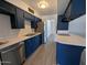 Well-lit kitchen with white countertops, navy cabinets, and stainless steel appliances at 2117 W 2Nd St, Mesa, AZ 85201