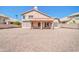 A covered patio extends from the house to a generously sized gravel backyard ready for landscaping at 22019 N 59Th Dr, Glendale, AZ 85310
