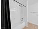 Bright bathroom featuring a bathtub with a shower, tiled flooring, and fixtures at 22019 N 59Th Dr, Glendale, AZ 85310