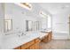 Bright bathroom with double sinks, a soaking tub, and a walk-in shower at 22019 N 59Th Dr, Glendale, AZ 85310