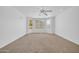 Large bedroom featuring neutral carpet, ceiling fan, and outdoor access at 22019 N 59Th Dr, Glendale, AZ 85310