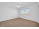 Bright bedroom featuring a large window, white walls, and neutral carpet flooring at 22019 N 59Th Dr, Glendale, AZ 85310