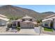 Two-story beige home with a large garage and mountain views in the background at 22019 N 59Th Dr, Glendale, AZ 85310