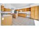 Spacious kitchen features tile flooring, light wood cabinets, an island, and breakfast bar at 22019 N 59Th Dr, Glendale, AZ 85310
