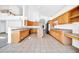 Bright kitchen features tile flooring, light wood cabinets, an island, and breakfast bar at 22019 N 59Th Dr, Glendale, AZ 85310