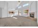 Sunlit living room featuring a vaulted ceiling, fireplace, and seamless access to the kitchen and dining areas at 22019 N 59Th Dr, Glendale, AZ 85310