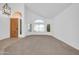 Bright living room with vaulted ceilings, lots of light, carpeted flooring, and arched windows at 22019 N 59Th Dr, Glendale, AZ 85310