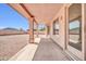 Covered patio showcasing a view of the spacious gravel backyard and desert landscape with blue sky views at 22019 N 59Th Dr, Glendale, AZ 85310