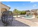 Beautiful backyard with a refreshing pool, mature trees, seating, and well-maintained landscaping at 2213 N Park Meadows Dr, Buckeye, AZ 85396
