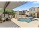 Inviting backyard featuring a cozy fire pit, outdoor seating, and a refreshing pool under a pergola at 2213 N Park Meadows Dr, Buckeye, AZ 85396