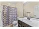 Well-lit bathroom featuring a shower with a patterned curtain at 2213 N Park Meadows Dr, Buckeye, AZ 85396