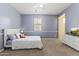Cozy bedroom featuring light blue walls, a ceiling fan, and a modern white dresser with a TV at 2213 N Park Meadows Dr, Buckeye, AZ 85396