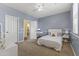 Inviting bedroom with light blue walls, a white bed, and a dedicated desk area for studying at 2213 N Park Meadows Dr, Buckeye, AZ 85396
