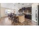 Open kitchen with dark cabinetry, granite countertops, stainless appliances, and a center island with seating at 2213 N Park Meadows Dr, Buckeye, AZ 85396