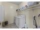 Functional laundry room with a washer, dryer, and shelving for storage at 2213 N Park Meadows Dr, Buckeye, AZ 85396